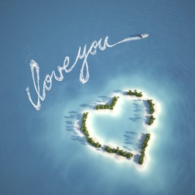 Île en forme de cœur avec "I love you" écrit dans le ciel.