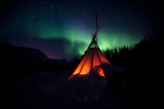 Tente au clair de lune sous des aurores boréales colorées.