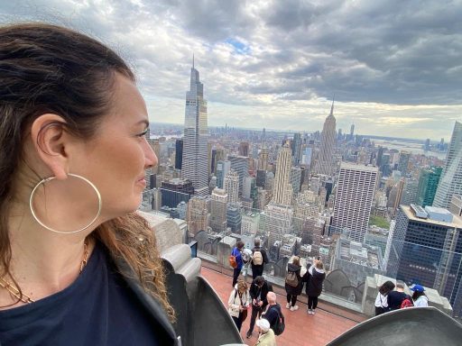 Femme admirant la vue de New York depuis un point de vue en hauteur.